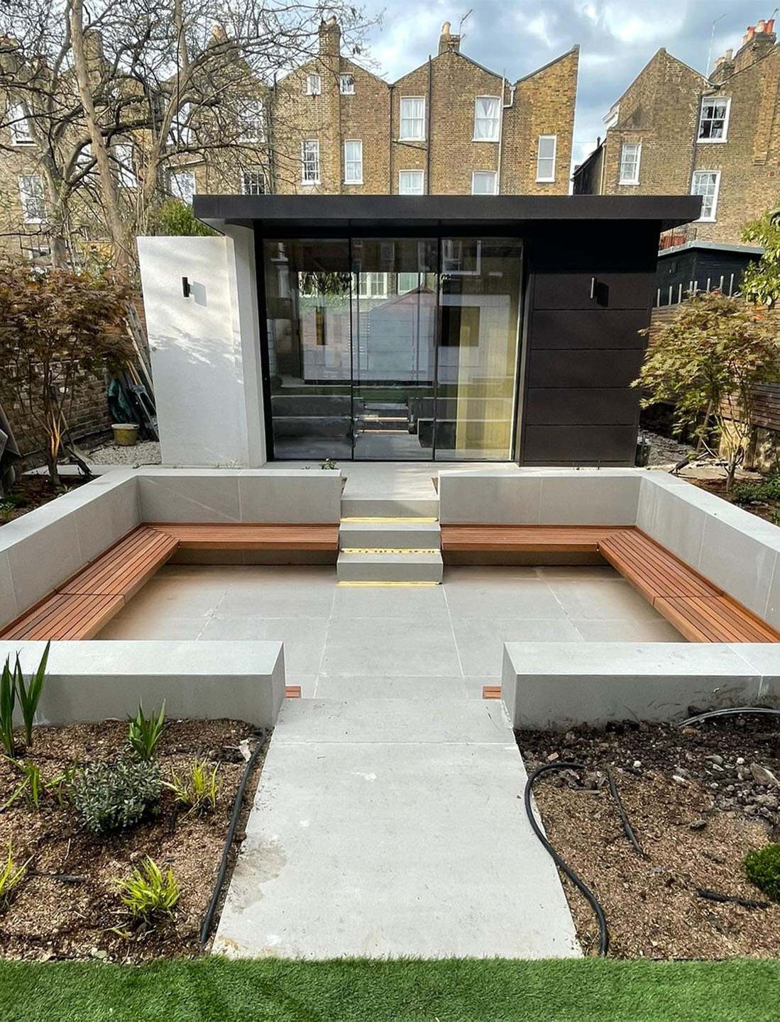 The garden building under construction, with concrete steps and bench seating