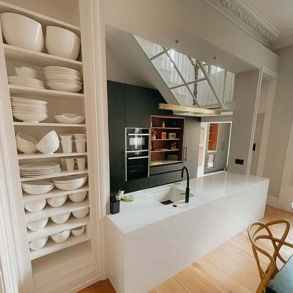 Kitchen with open shelving, a rooflight and an island at Englefield Road
